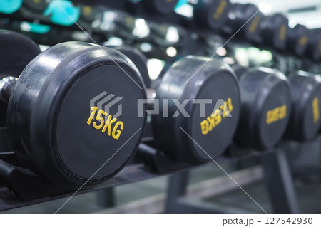 Stylish gym interior with dumbbells on display 127542930