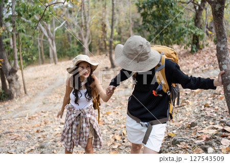 Happy LGBT Lesbian couple Travelers Hiking with Backpacks in waterfall Trail. LGBT Lesbian Couple Hikers with backpacks walks in mountains in vacation Happy LGBT Lesbian couple Travelers Hiking with Backpacks in waterfall Trail. LGBT Lesbian Couple Hikers with backpacks walks in mountains in vacation 127543509