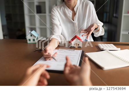 real estate agent discussion to explaining about property investment document with home sales contract and home insurance to customer while businessman asking terms data of contract 127543694