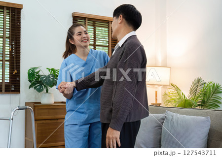 caregiver or nurse help support elderly are walk without walker at home 127543711