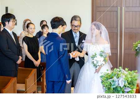 バージンロードを歩く新郎新婦と父親 127543833