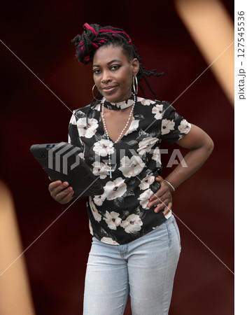 Stylish African American Woman with Colorful Braids Holding Smartphone in Floral Top Stylish African American Woman with Colorful Braids Holding Smartphone in Floral Top 127545536