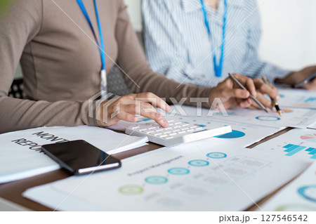 Businesspeople team collaboration analyzing monthly financial report with graph and chart. Analyzing result, Businesswoman accountant or financial expert analyze business 127546542