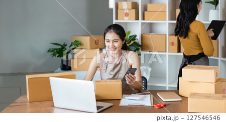 Young business entrepreneur using laptop. Preparing for shipping, online selling, e-commerce concept Young business entrepreneur using laptop. Preparing for shipping, online selling, e-commerce concept 127546546