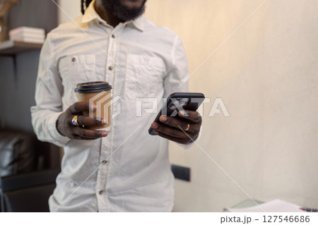 African American business man working with document and laptop while talking on mobile at home on couch. work from home concept African American business man working with document and laptop while talking on mobile at home on couch. work from home concept 127546686