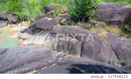 Tropical Granite Rock Formations with Stream in Lush Forest Tropical Granite Rock Formations with Stream in Lush Forest 127548223