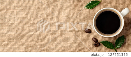 Cozy Coffee Cup Resting on Burlap Sack with Single Fresh Sprig Cozy Coffee Cup Resting on Burlap Sack with Single Fresh Sprig 127551556