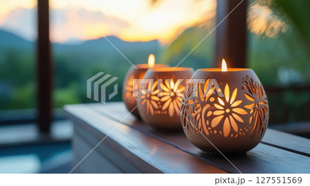 Glowing Coconut Shell Candles with Intricate Carvings in Natural Setting 127551569