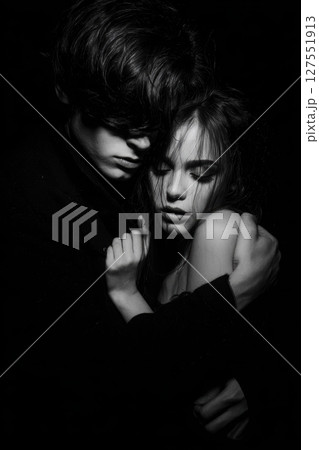Dark photo of big man hugging his woman tightly, both showing deep emotional connection 127551913