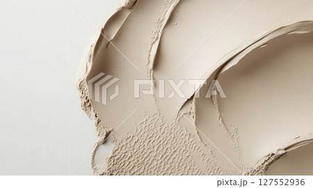 a close up shot reveals a thick, swirled substance against a flat backdrop. the substance, varying in texture, spreads across the right side, curving to the lower left area 127552936