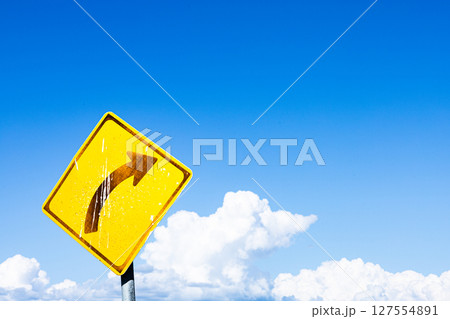 青空と雲と右カーブの標識のあるシンプルな風景 127554891