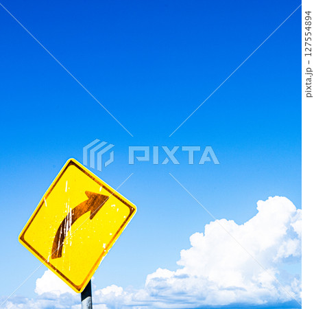 青空と雲と右カーブの標識のあるシンプルな風景 127554894
