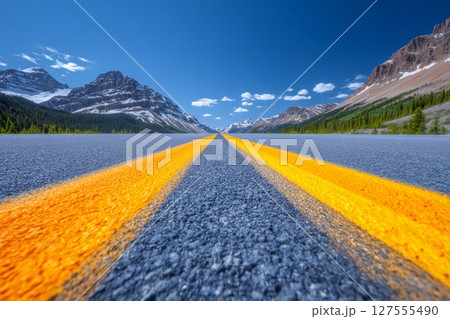 On a Spring evening, the view from Icefields Parkway at Bow Lake reveals the parkway's path towards the lake, set against the stunning backdrop of BowCrow Peak, Crowfoot Glacier, and Crowfoot 127555490