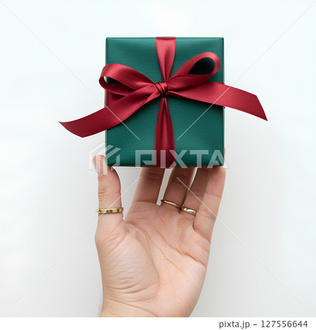 Blank hand holding small gift box mockup, isolated on white background. Present or surprise concept design for holidays, events, or love themes. 127556644