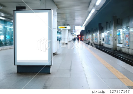 Empty billboard at bustling metro platform. Sleek ad display catches eye in busy transit hub, great for commercial or campaign visuals. Perfect for city or travel advertising. 127557147