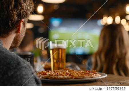 Watching Live Sports Game with Beer and Pizza at Cozy Bar 127559365