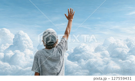 Young Man Reaching to the Sky from the Clouds 127559431