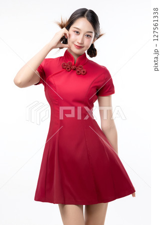 Portrait of joyful beauty Asian woman in red Cheongsam Chinese traditional dress celebrating and making heart shape hand sign isolated on white background. 127561338