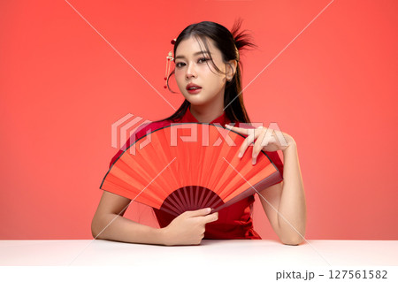 Portrait of beauty Asian woman in red Cheongsam Chinese traditional dress isolated on red background. 127561582