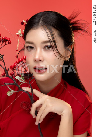 Portrait of beauty Asian woman in red Cheongsam Chinese traditional dress isolated on red background. 127561583