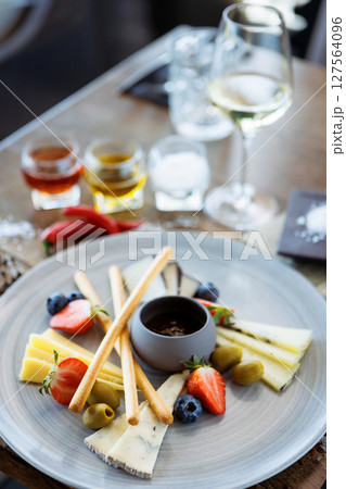 Cheese platter for two: Goat cheese cream, gorgonzola, camembert, grissini and fig jam. Delicious healthy Italian traditional food closeup served for lunch in modern gourmet cuisine restaurant 127564096