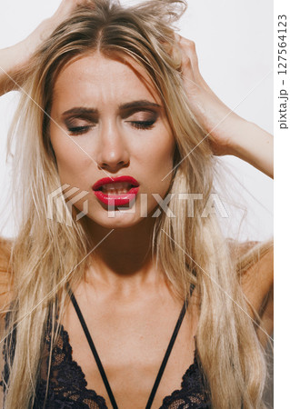 emotions and feelings concept - breathtaking blonde lady in delicate lingerie, experiencing pure passion, eyes shut, lips parted, body shivering in ecstasy against a bright white background emotions and feelings concept - breathtaking blonde lady in delicate lingerie, experiencing pure passion, eyes shut, lips parted, body shivering in ecstasy against a bright white background 127564123