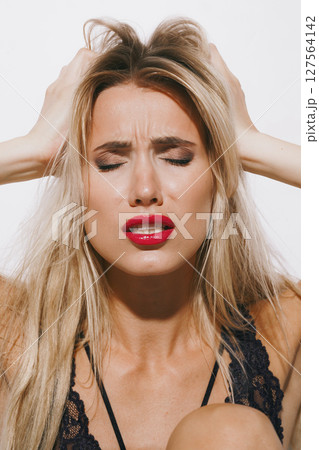 emotions and feelings concept - beautiful blonde in delicate lingerie, moaning in deep pleasure, trembling as she surrenders to passion, eyes closed, fully immersed in orgasmic delight 127564142