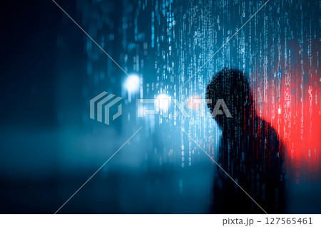 暗い背景にネオンカラーのバイナリコードがストリーム状に降り注ぎフードを被った匿名ハッカーのシルエット 127565461