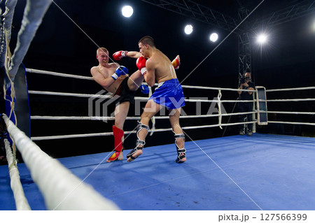 Kickboxing rivals unleash powerful leg strikes in a thrilling match. 127566399