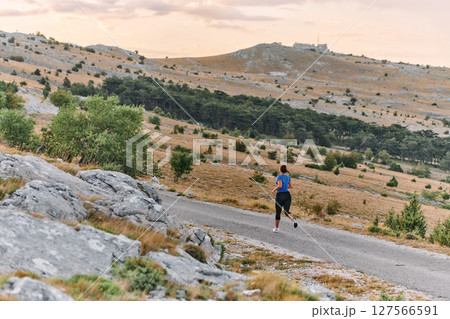 Empowered Runner Embracing Nature's Beauty on a Serene Morning Trail. 127566591