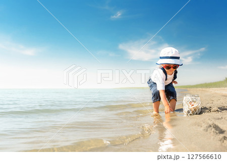 Kid play on the beach on a hot sunny day 127566610