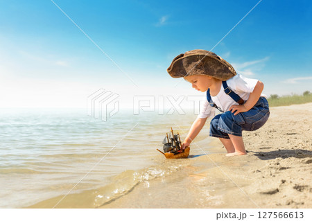 Kid play on the beach on a hot sunny day 127566613