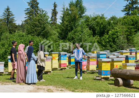A diverse group of young friends and entrepreneurs explore small honey production businesses in the natural setting of the countryside. 127566621