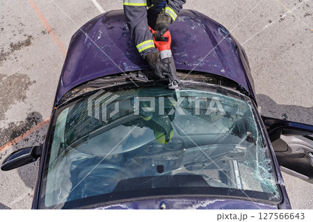 A dedicated team of professional firefighters employs specialized tools to cut and break through vehicle wreckage, showcasing their skilled collaboration and swift response in rescuing individuals A dedicated team of professional firefighters employs specialized tools to cut and break through vehicle wreckage, showcasing their skilled collaboration and swift response in rescuing individuals 127566643