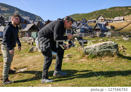 A skilled videographer, equipped with professional gear, captures the essence of nature's beauty, expertly documenting the scenic landscape in a cinematic masterpiece that reflects the seamless blend 127566793