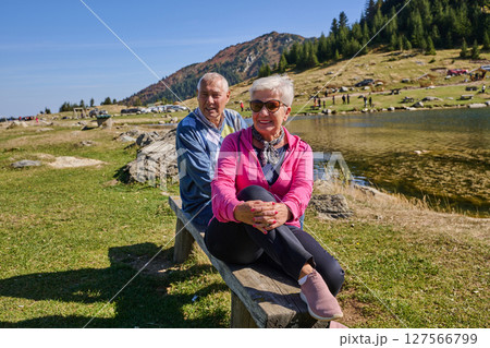 Elderly couple finding solace and joy as they rest on a park bench, engaged in heartfelt conversation, following a rejuvenating strol a testament to the enduring companionship and serene connection 127566799