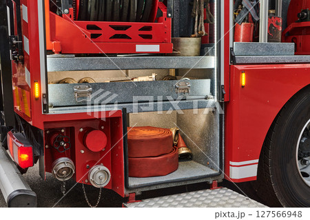 Close-up of essential firefighting equipment on a modern firetruck, showcasing tools and gear ready for emergency response to hazardous fire situations Close-up of essential firefighting equipment on a modern firetruck, showcasing tools and gear ready for emergency response to hazardous fire situations 127566948