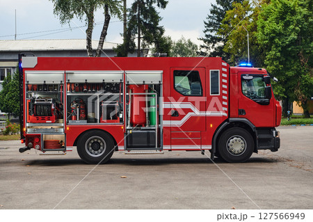 A state-of-the-art firetruck, equipped with advanced rescue technology, stands ready with its skilled firefighting team, prepared to intervene and respond rapidly to emergencies, ensuring the safety 127566949