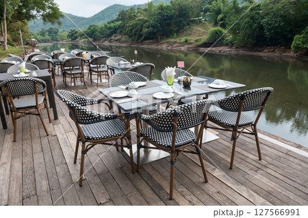 Outdoor restaurant table on wood terrace by kwai river, Kanchanaburi 127566991