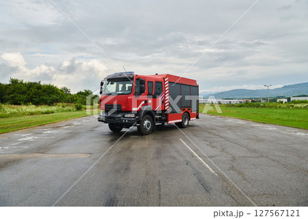 In this captivating scene, a state-of-the-art firetruck, equipped with advanced rescue technology, stands ready with its skilled firefighting team, prepared to intervene and respond rapidly to 127567121