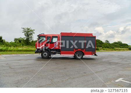 In this captivating scene, a state-of-the-art firetruck, equipped with advanced rescue technology, stands ready with its skilled firefighting team, prepared to intervene and respond rapidly to In this captivating scene, a state-of-the-art firetruck, equipped with advanced rescue technology, stands ready with its skilled firefighting team, prepared to intervene and respond rapidly to 127567135