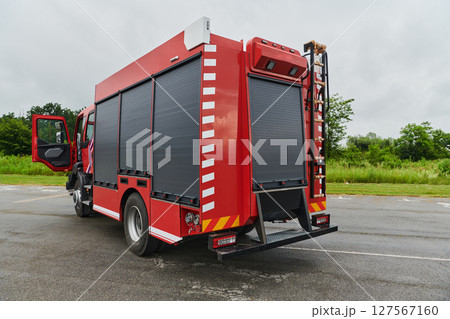 In this captivating scene, a state-of-the-art firetruck, equipped with advanced rescue technology, stands ready with its skilled firefighting team, prepared to intervene and respond rapidly to In this captivating scene, a state-of-the-art firetruck, equipped with advanced rescue technology, stands ready with its skilled firefighting team, prepared to intervene and respond rapidly to 127567160