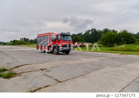 In this captivating scene, a state-of-the-art firetruck, equipped with advanced rescue technology, stands ready with its skilled firefighting team, prepared to intervene and respond rapidly to 127567175