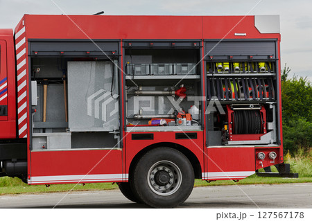In this captivating scene, a state-of-the-art firetruck, equipped with advanced rescue technology, stands ready with its skilled firefighting team, prepared to intervene and respond rapidly to 127567178