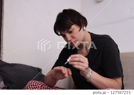 Young woman applying nail polish at home Young woman applying nail polish at home 127567253