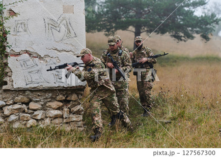 In a high stakes mission, a specialized military unit executes a tactical operation to secure a dangerous house where terrorists are believed to be hiding, showcasing precision and coordinated In a high stakes mission, a specialized military unit executes a tactical operation to secure a dangerous house where terrorists are believed to be hiding, showcasing precision and coordinated 127567300