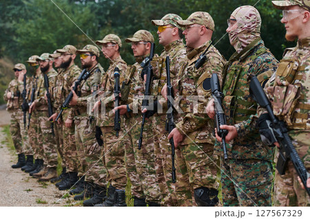 Soldier fighters standing together with guns. Group portrait of US army elite members, private military company servicemen, anti terrorist squad 127567329
