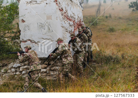 In a high stakes mission, a specialized military unit executes a tactical operation to secure a dangerous house where terrorists are believed to be hiding, showcasing precision and coordinated In a high stakes mission, a specialized military unit executes a tactical operation to secure a dangerous house where terrorists are believed to be hiding, showcasing precision and coordinated 127567333