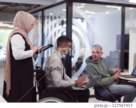 Young group of business people brainstorming together in a startup space, discussing business projects, investments, and solving challenges. Young group of business people brainstorming together in a startup space, discussing business projects, investments, and solving challenges. 127567457