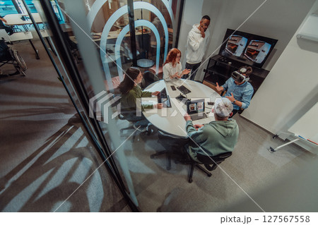 A diverse group of businessmen collaborates and tests a new virtual reality technology, wearing virtual glasses, showcasing innovation and creativity in their futuristic workspace 127567558